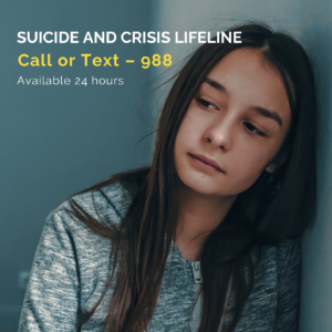 Young person leaning on a hall with the suicide and crisis lifeline number. Reading call or text 988 available 24 hours. 